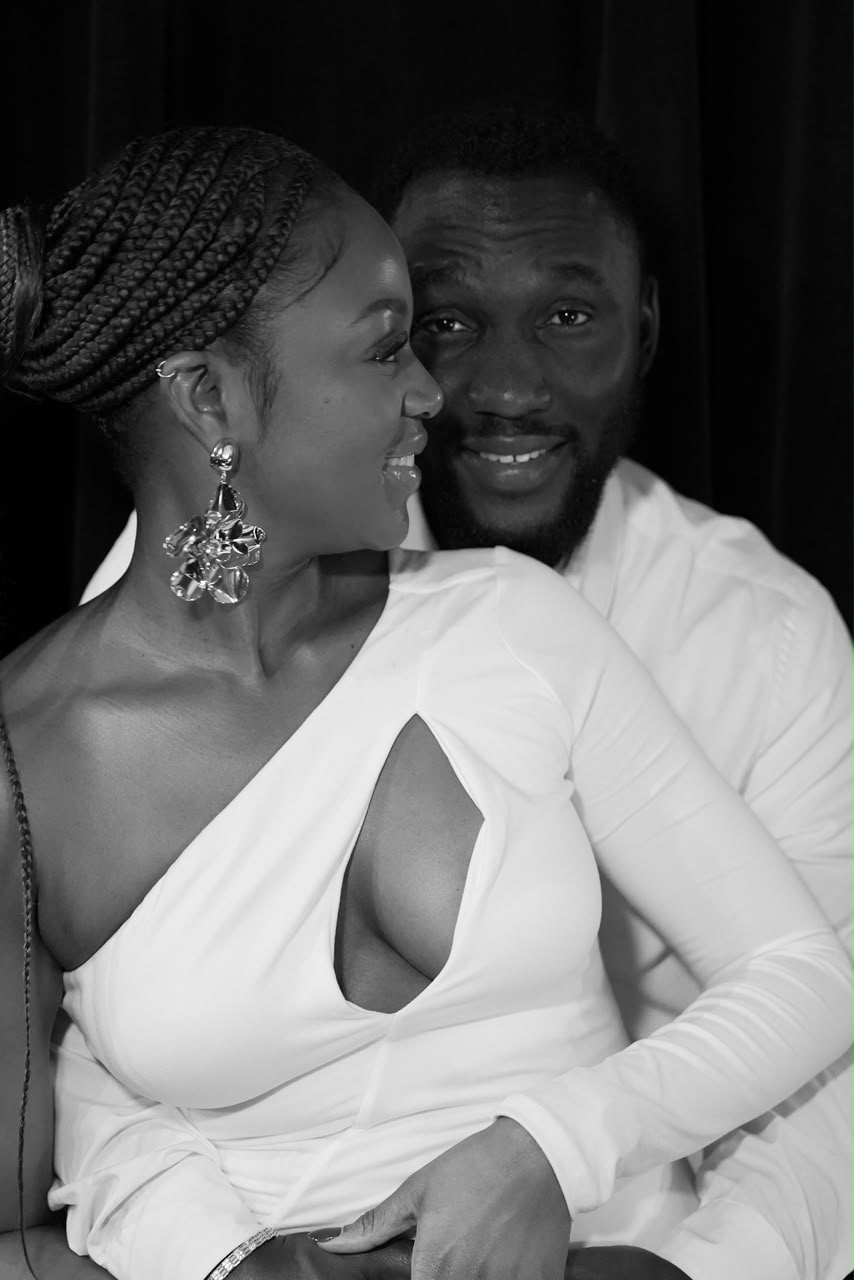 Harrison and Otobong smiling together in black and white